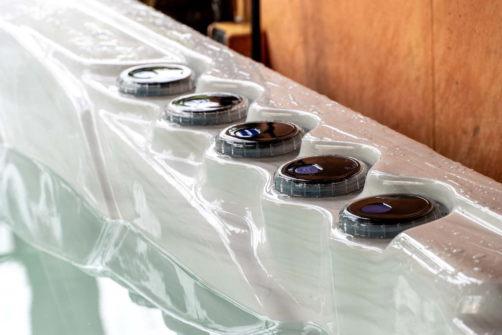 Witte jacuzzi buiten met meerdere ronde bedieningsknoppen voor swimspa en ijsbaden.