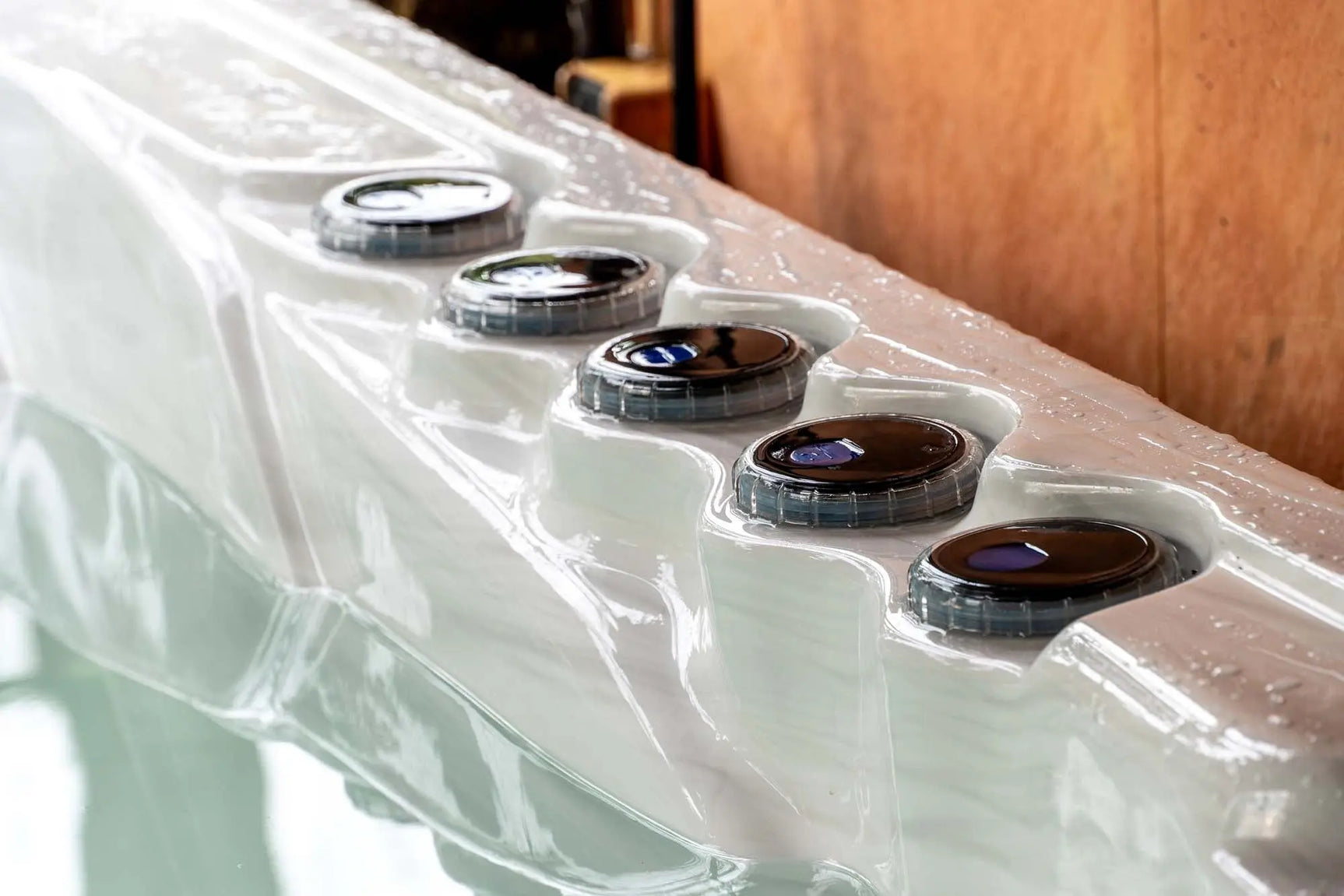 Witte jacuzzi buiten met meerdere ronde bedieningsknoppen voor swimspa en ijsbaden.