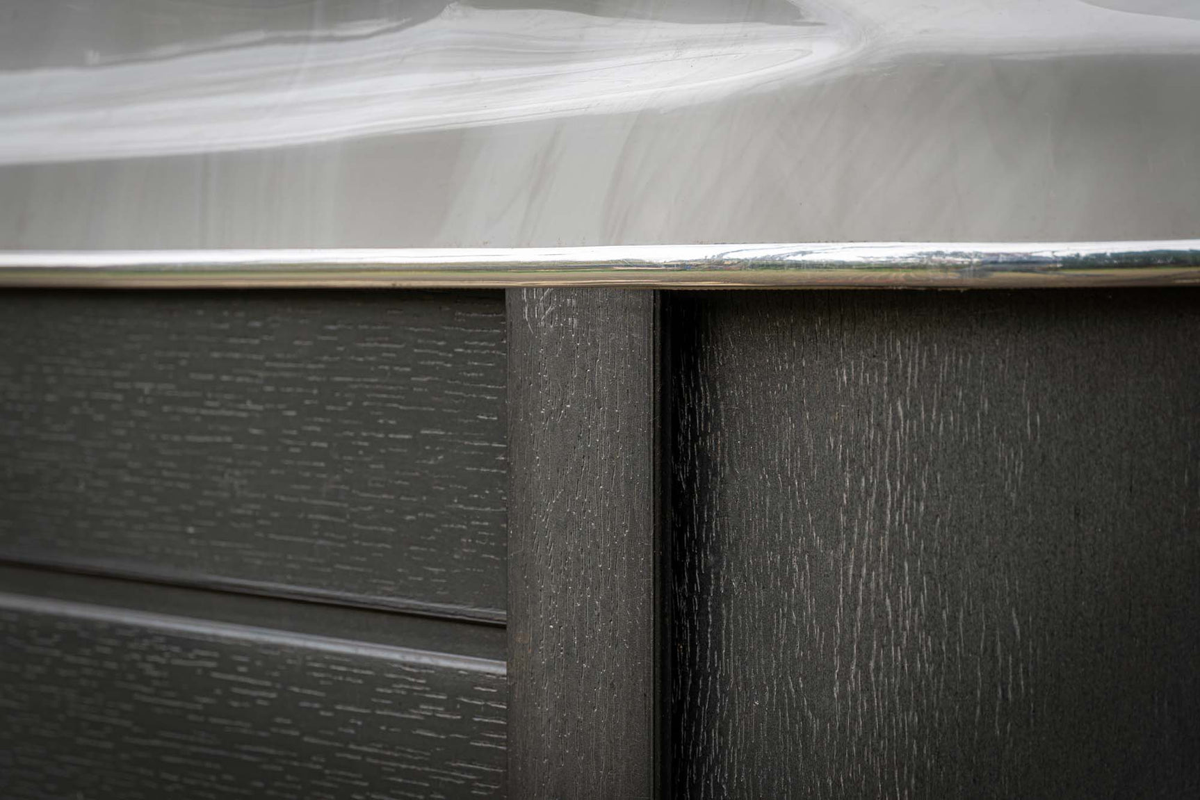 Close-up van hoek met houtstructuur en witte rand van jacuzzi zwemspa voor buitengebruik.