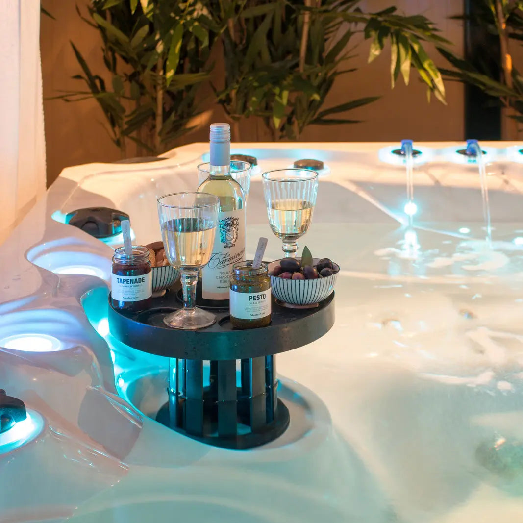 Zwarte skimmer bar in jacuzzi met glazen, flesjes en snacks voor zwemspa en swimspa accessoires jacuzzi buiten.