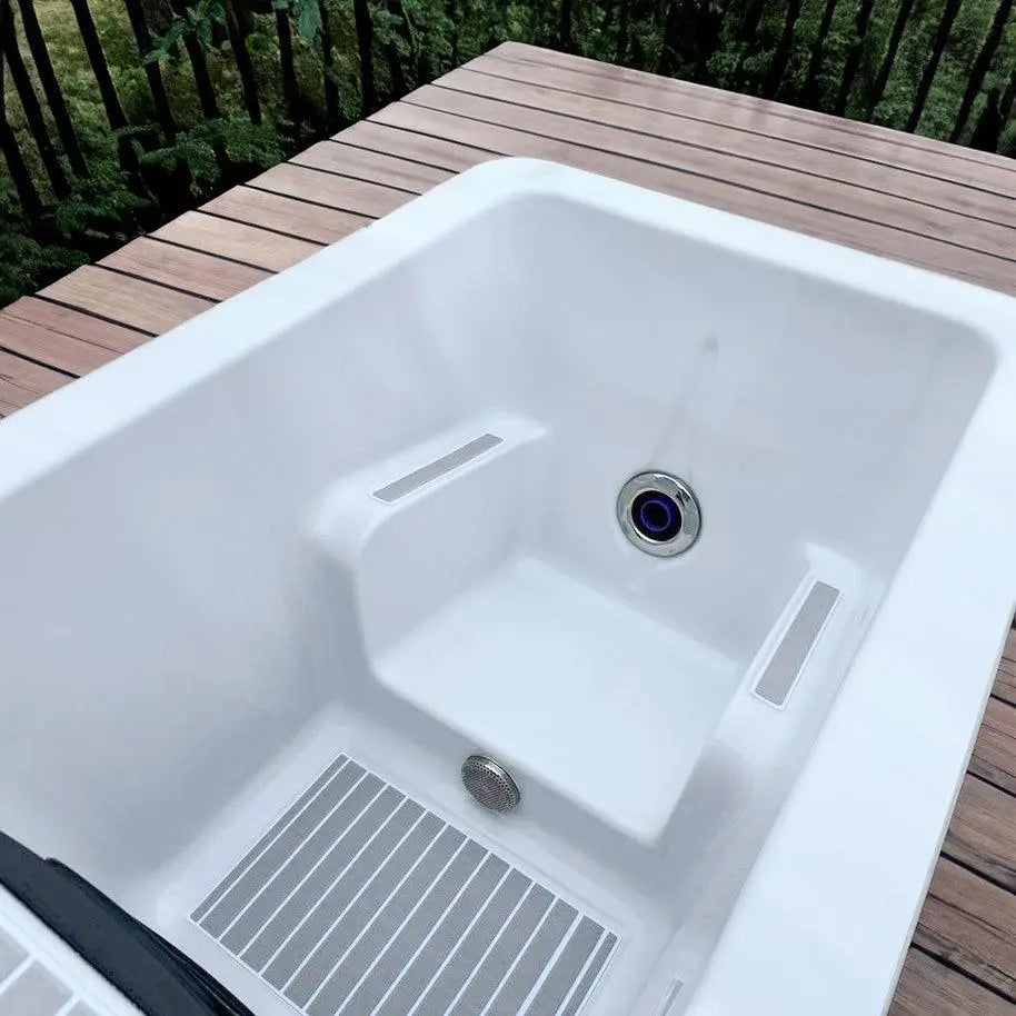 Witte moderne jacuzzi buiten met geïntegreerde zithoek en strakke afwerking, ideaal als zwemspa of swimspa bij jacuzzi kopen.