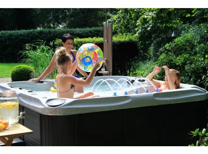 Summer backyard relaxation in Euphoria spa with beach ball entertainment, showcasing luxurious garden setting - Passion Spas Exclusive Collection