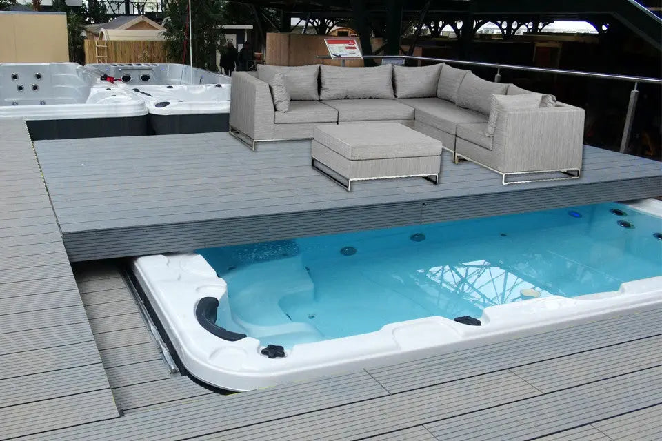 Strakke witte zwemspa ingebouwd in houten terras met moderne loungebank, perfect als jacuzzi buiten.