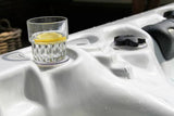 Glass of citrus drink on Felicity luxury hot tub edge, white shell detail, Passion Spas Exclusive Collection