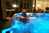 Refresh spa with illuminated blue LED lighting in evening setting, featuring therapeutic lounge seating - Passion Spas Pure Collection Hot Tubs