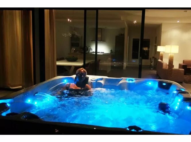 Euphoria spa with blue LED lighting at night, showcasing therapeutic jets and relaxation features - Passion Spas Exclusive Collection